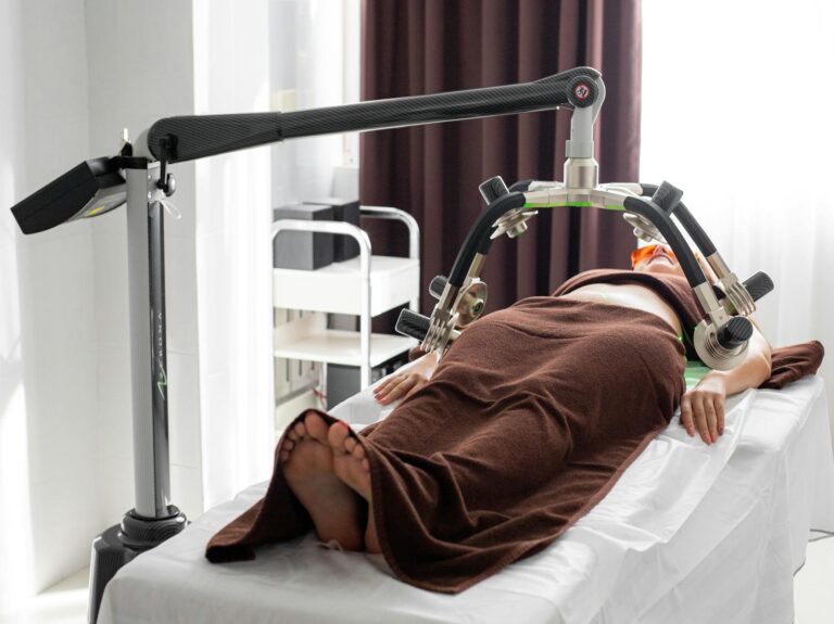 A woman undergoes a non-invasive body sculpting procedure in a contemporary spa clinic.